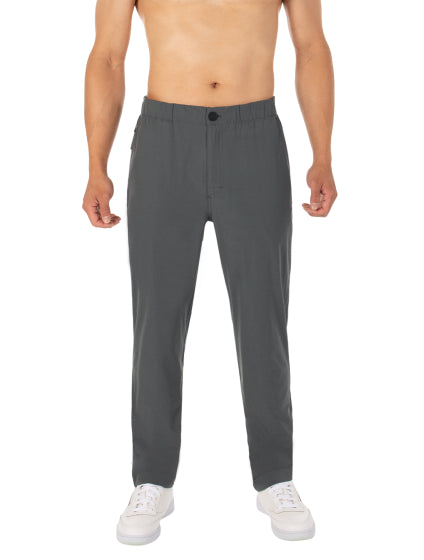 A photo of a man’s legs and feet from below the chest. He is wearing a pair of pants and running shoes.  