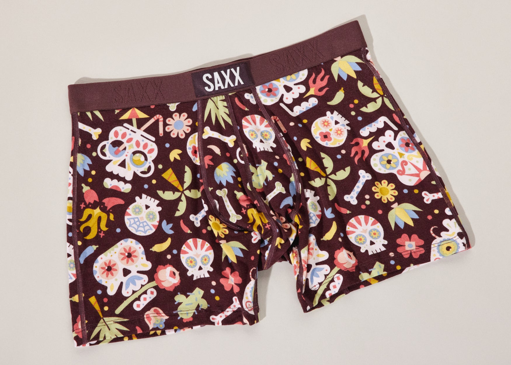 A pair of brown boxer briefs with a Mexican inspired day of the dead print including colorful skulls and palm trees.