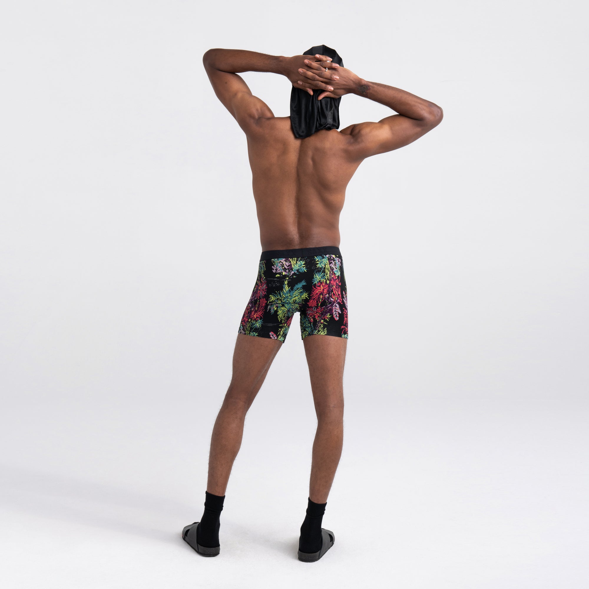 Back - Model wearing Vibe Super Soft Boxer Brief in Midnight Tropics- Multi