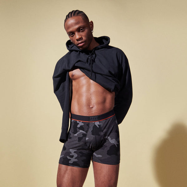 Model posing in Vibe Super Soft Boxer Brief in Supersize Camo- Black