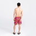 Back - Model wearing Oh Buoy 2N1 Swim Volley Short 7" in Mega Mega Melon- Red